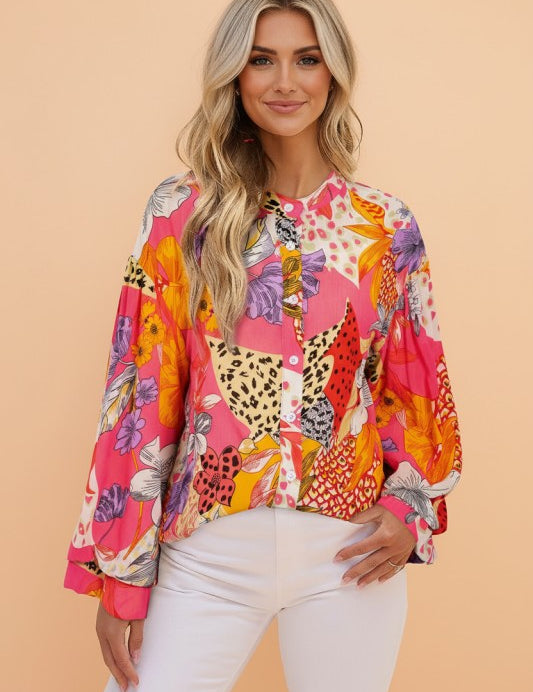 Woman wearing a colorful patterned blouse against a beige background