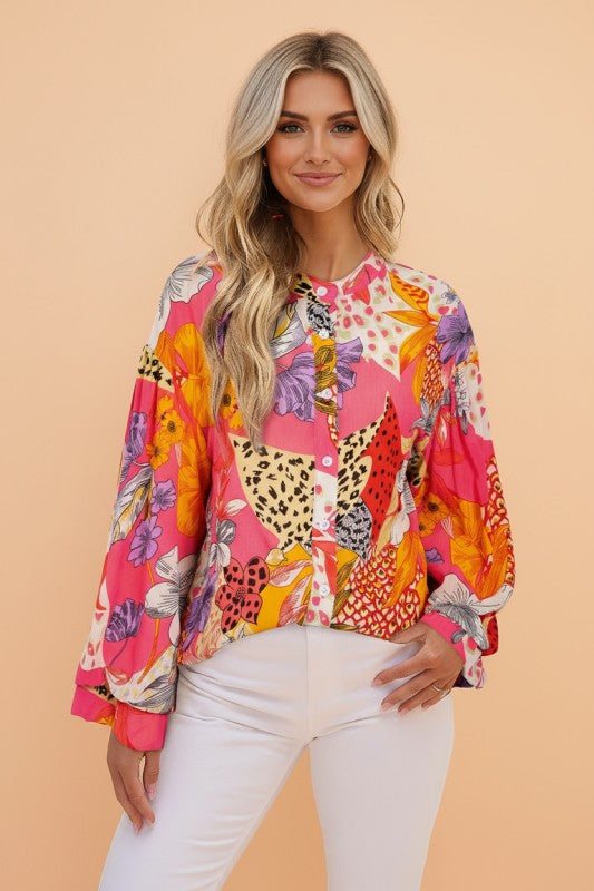 Woman wearing a colorful patterned blouse against a beige background