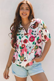 Woman wearing a colorful, floral short-sleeve blouse against a white background