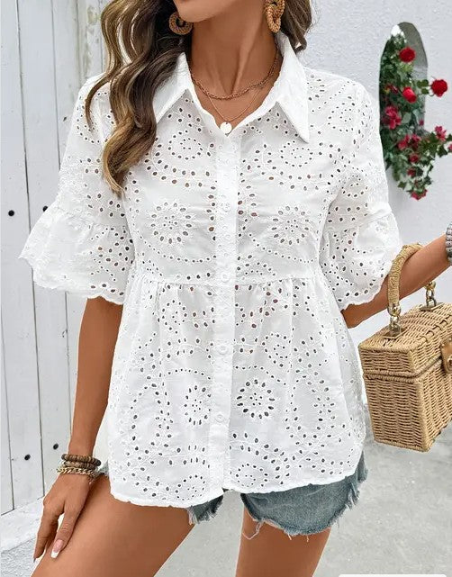 Woman wearing a feminine white eyelet button-up blouse with a collar.