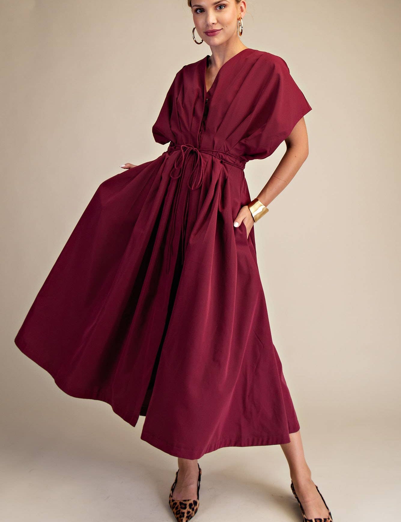 Woman wearing a burgundy dress with a plain background