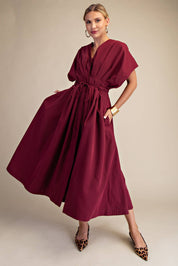 Woman wearing a burgundy dress with a plain background